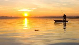 Foto di un pescatore all'alba (Depositphotos)