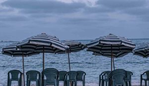 Ombrelloni aperti sulla spiaggia con sedie